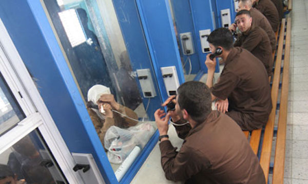 Palestinian men sit in their brown priso