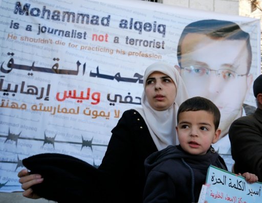 © AFP/File | The wife of Palestinian imprisoned journalist Mohammed al-Qiq, Fayha Shalash, flanked by her son Islam, addresses journalists during a press conference on her husband's health situation on January 31, 2016