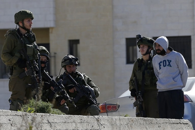 Israeli soldiers arrest a Palestinian man on February 15, 2016 at the Amari Palestinian refugee camp, near the West Bank city of Ramallah, during clashes with Israeli soldiers that erupted after they entered the camp early in the morning.   / AFP / ABBAS MOMANI