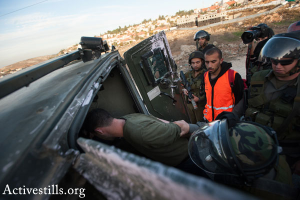 Israeli soldiers arresting a Palestinian man (Activestills.org)