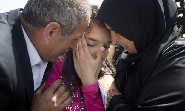 Dima al-Wawi is greeted by her mother, Sabha al-Wawi, and father, Ismail al-Wawi, at a checkpoint on Sunday, 24 April. Photograph: Majdi Mohammed/AP Photo