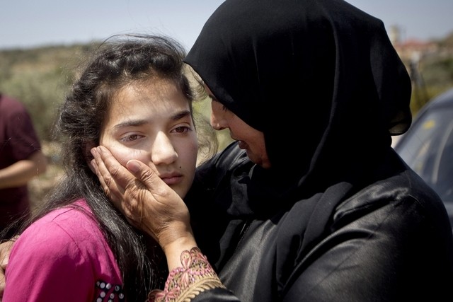 Sabha Al Wawi comforts her 12-year-old daughter, Dima, after her release from an Israeli prison, near the West Bank town of Tulkarem. Majdi Mohammed / AP Photo