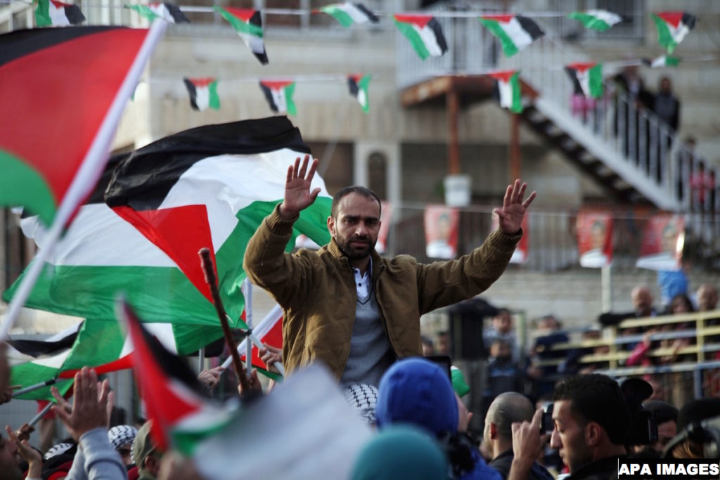 Palestinian prisoner Samer al-Issawi, who held a hunger strike for eight months, is greeted by people  during  celebrates his release from an Israeli jail in the East Jerusalem neighborhood of Issawiya,  December 28, 2013. Israel freed al-Issawi from jail after completing a deal agreed in exchange for him halting the hunger strike that almost killed him. His confinement had stoked weeks of protests in the Israeli-occupied West Bank. Israel convicted Issawi of shooting at an Israeli bus in 2002 but released him in 2011 along with more than 1,000 Palestinian prisoners. He was re-arrested in July 2012 after Israel said he violated the terms of his release by crossing from his native East Jerusalem to the West Bank. Photo by Saeed Qaq