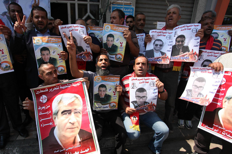 Palestinians hold banners during a solidarity rally for Palestinian prisoners on hunger strike in Israeli jails, in Gaza City on 8 September. Ashraf Amra APA images