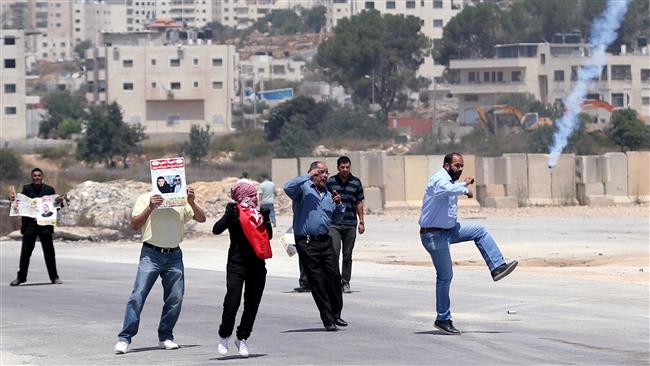 Palestinian protesters react to a tear gas canister fired by Israeli troops during clashes following a protest in solidarity with Palestinian prisoners held in Israeli jails, in the West Bank town of Beitunia near the Israeli Ofer prison, August 18, 2016. ©Reuters