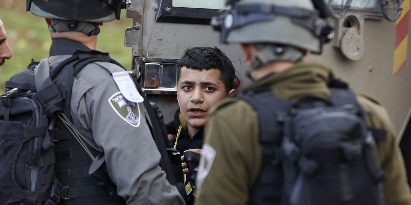 Israeli officers arrested a Palestinian boy during a 2017 protest outside an Israeli military prison in the occupied West Bank. Photo: Majdi Mohammed/AP