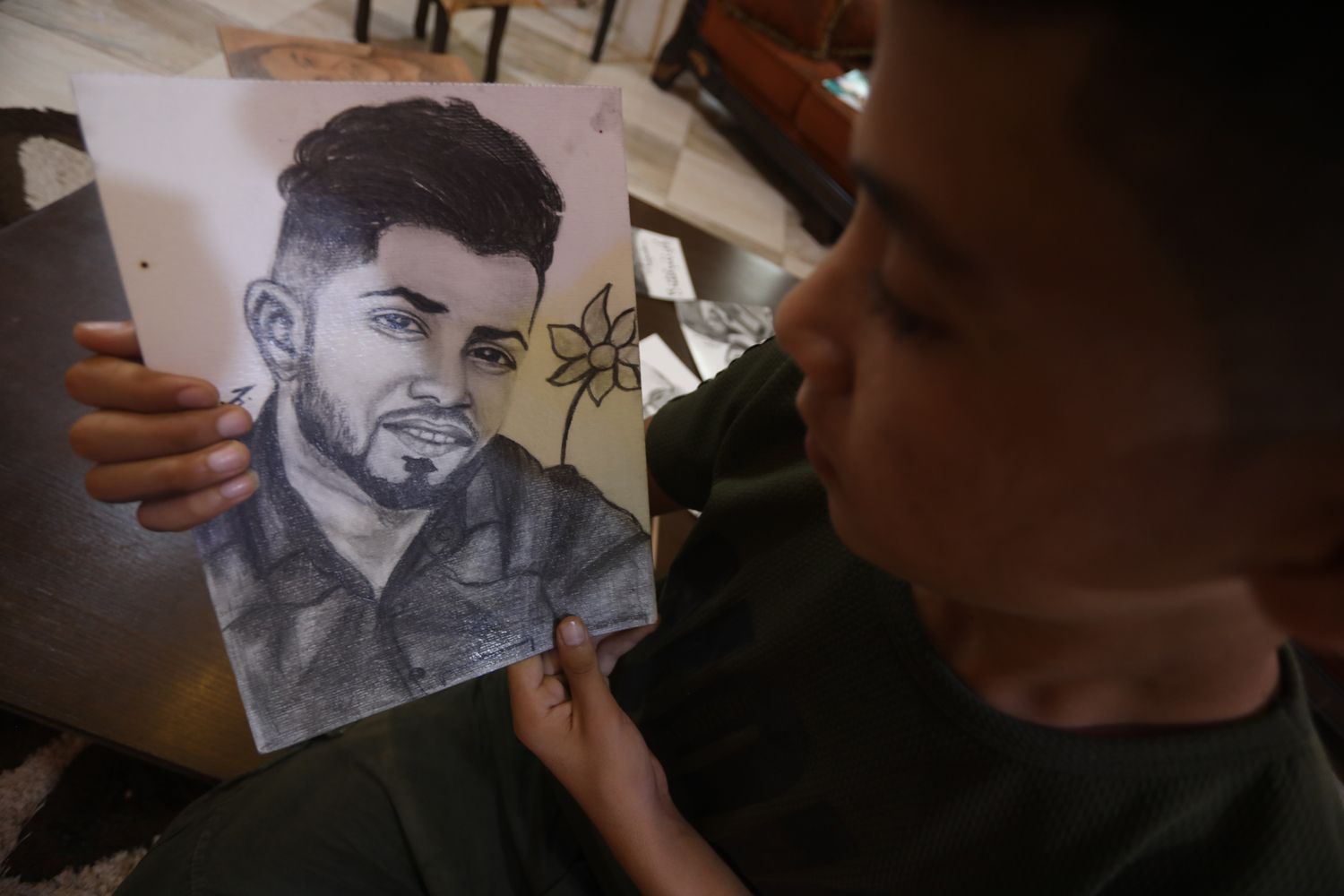 Jamil holding a portrait of his friend, Tamer Abu al-Khair. (Photo: Mohammed Asad)