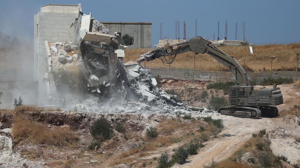 Israeli military machinery demolishes a Palestinian building in the village of Sur Baher which sits on either side of the Israeli barrier in East Jerusalem and the Israeli-occupied West Bank on July 22, 2019. (Reuters)