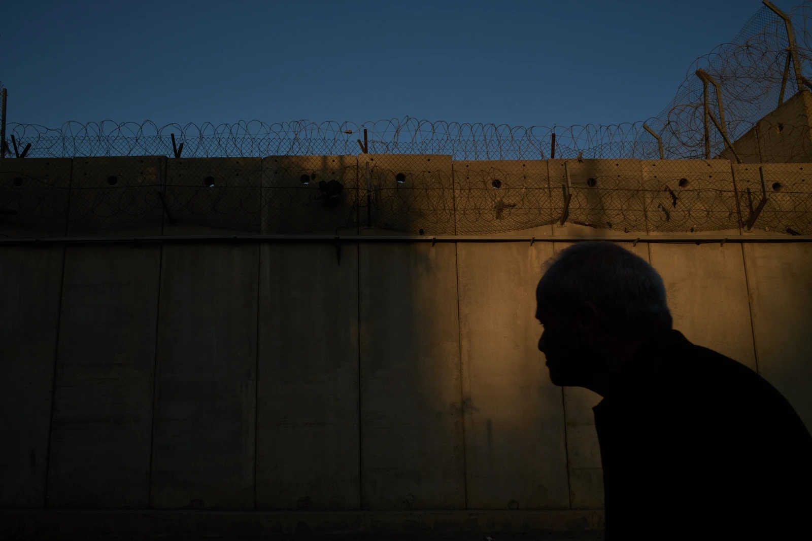 An elderly man walks on a street beside Israel's separation wall in the Beit Hanina neighborhood, in East Jerusalem, Wednesday, Oct. 7, 2026. (AP Photo/Leo Correa)